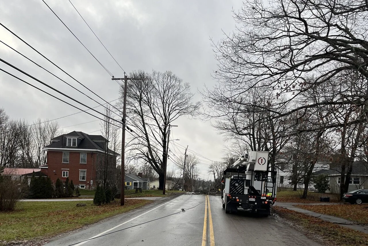 A truck driving down the street in front of houses.